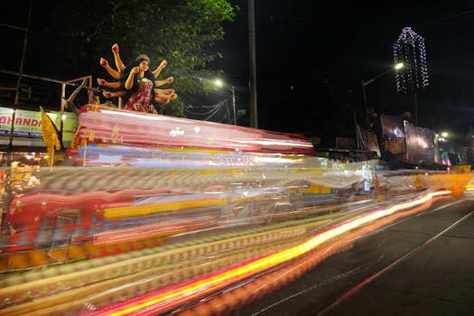 Dynamic long-exposure night shot capturing Durga idol procession in Kolkata, India.