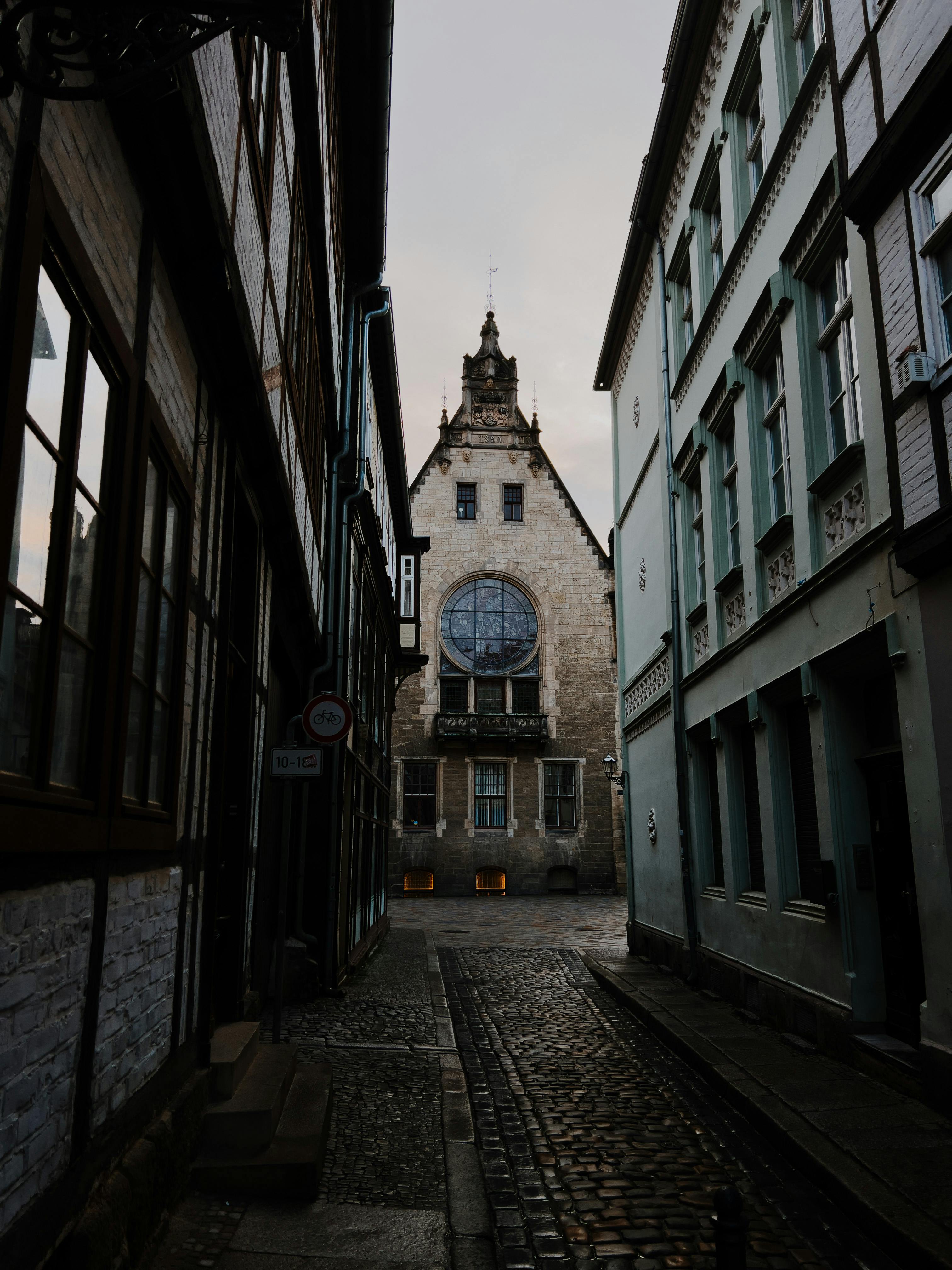 Charming cobblestone street in Quedlinburg featuring historic Gothic architecture under a moody sky.