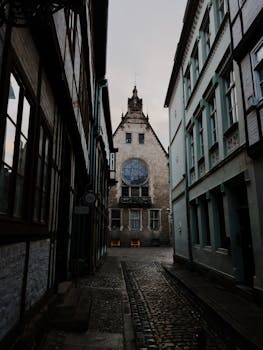Charming cobblestone street in Quedlinburg featuring historic Gothic architecture under a moody sky.