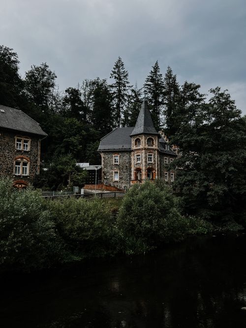 Free Charming stone building in a verdant forest landscape, ideal for travel and nature themes. Stock Photo
