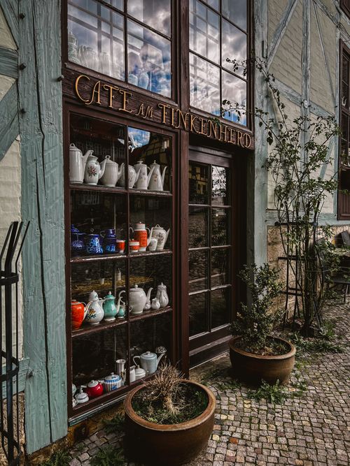 Free Explore the vintage charm of Café am Finkenherd in Quedlinburg, Germany, featuring a display of colorful teapots. Stock Photo