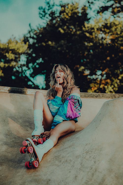 Woman on Roller Skates Sitting at Skatepark