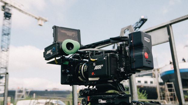 Professional film camera setup outdoors capturing a scene with blurred background.