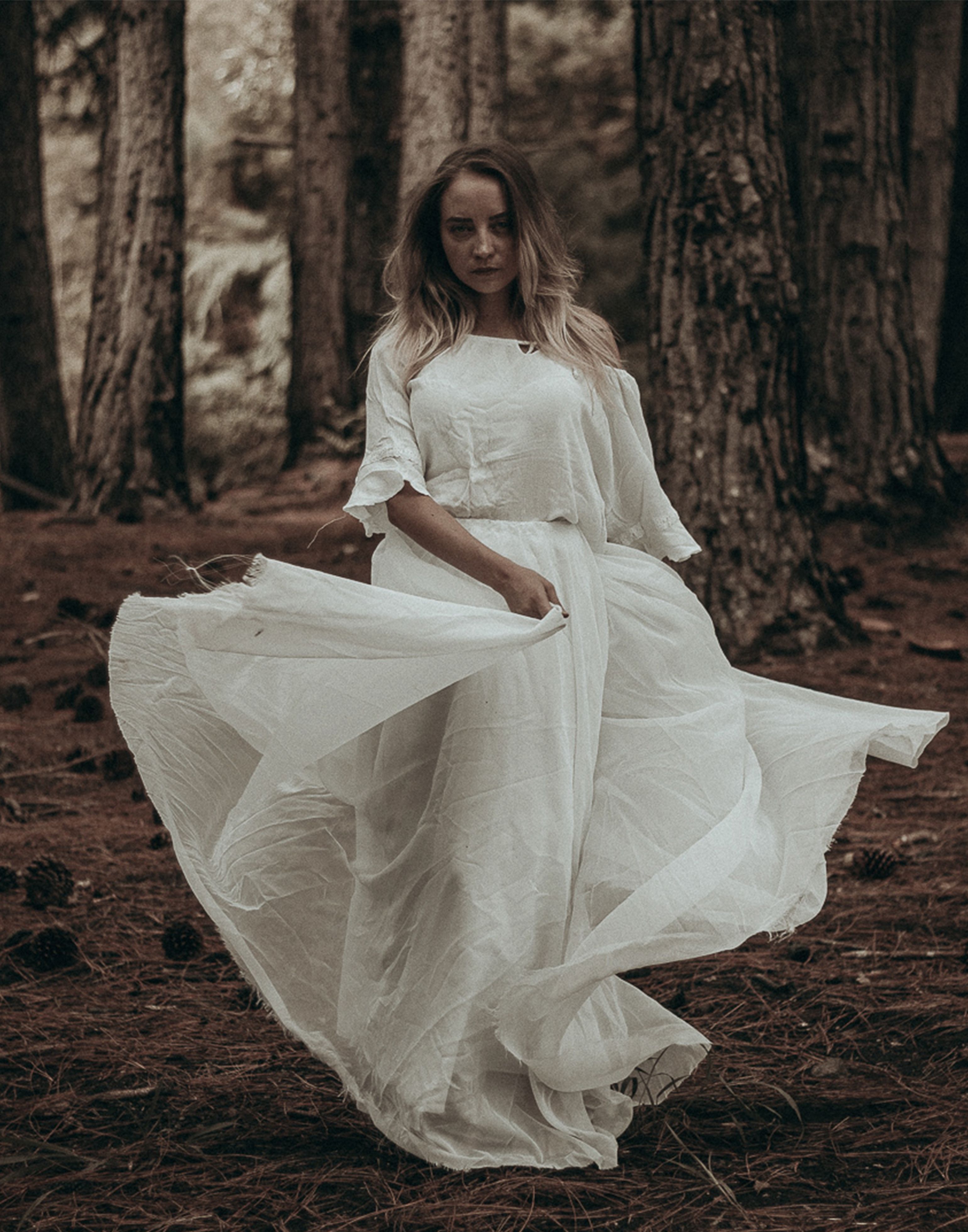 Woman in a White Dress and Veil Standing in the Forest  Free Stock Photo