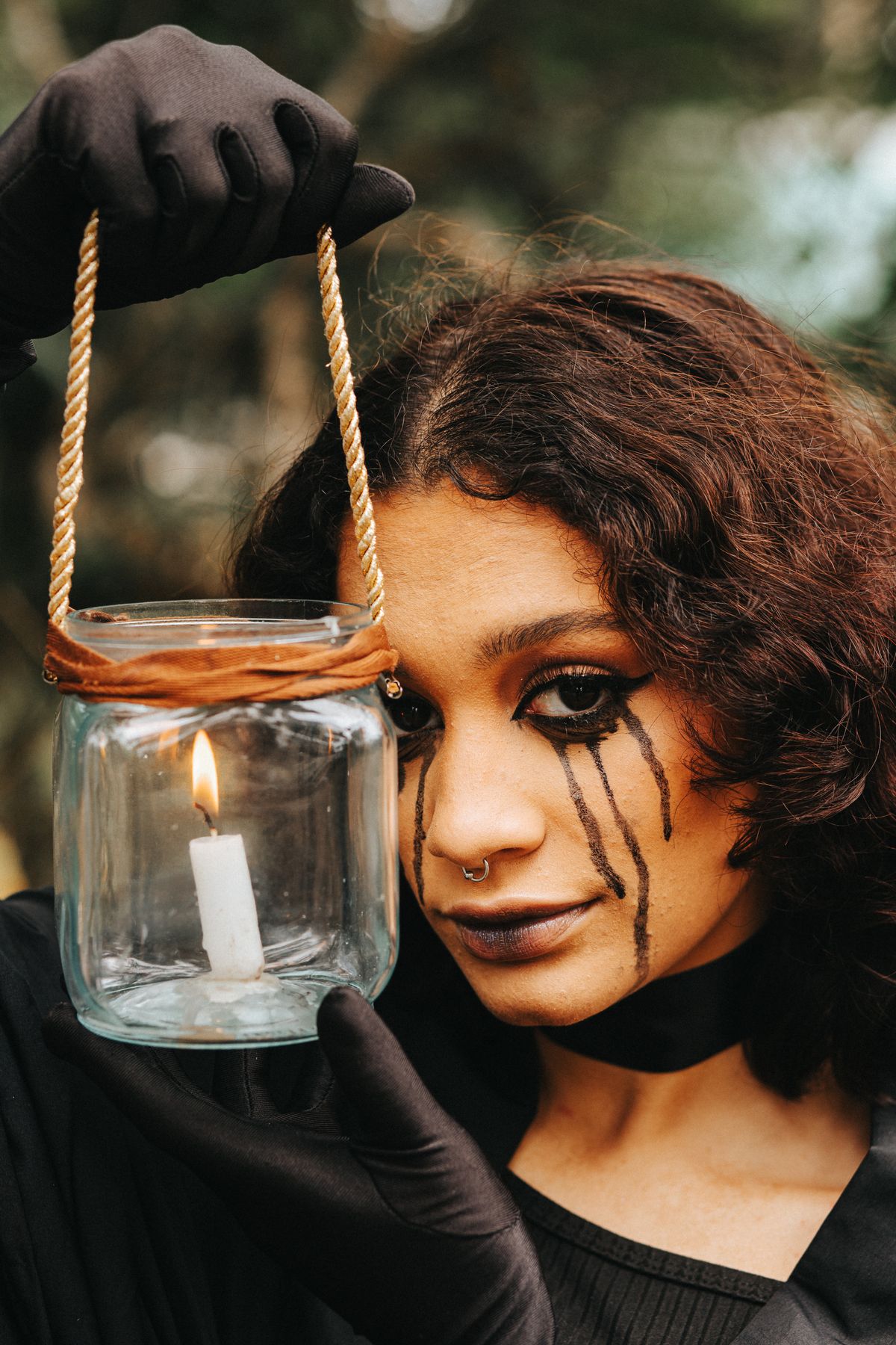 Woman with dramatic Halloween makeup holding a glowing lantern