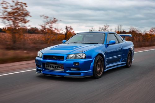 Free Dynamic image of a blue sports car cruising down an open road during the day. Ideal for automotive themes. Stock Photo