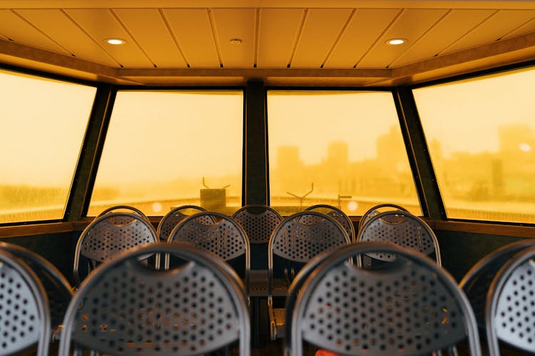 Yellow And Wet Ferry Windows Over Metal Chairs