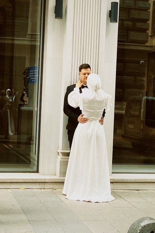 Newlyweds Embracing on Sidewalk