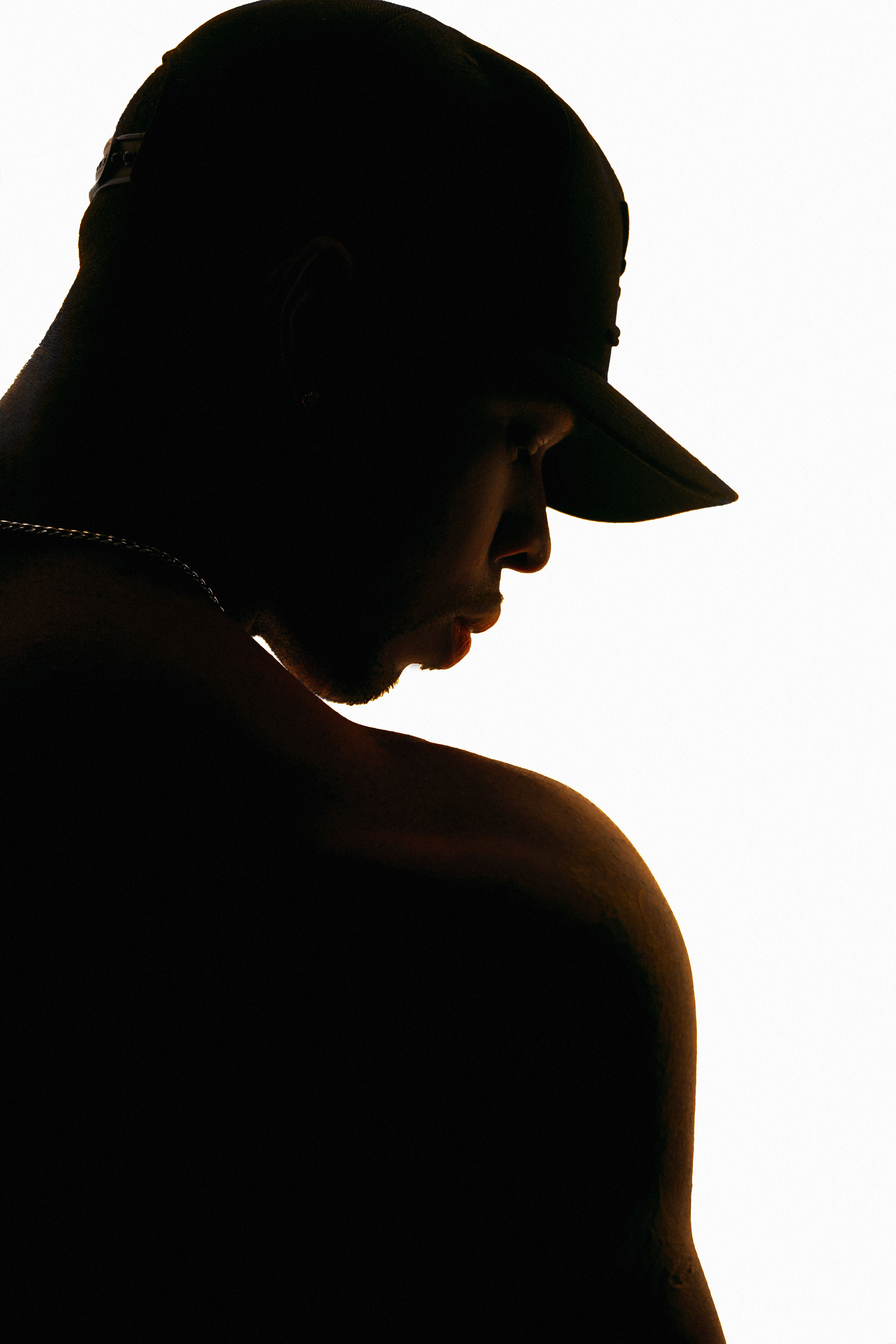 Artistic silhouette of a man in a cap against a white background.