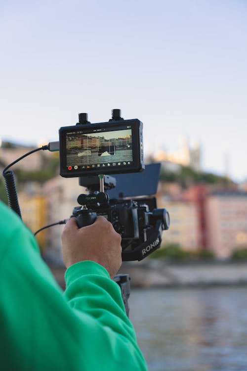 Close-up of a Man Operating a Camera Outside in City