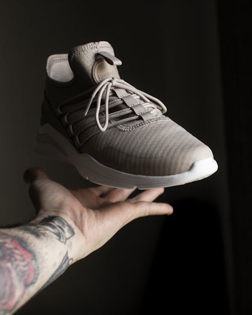免费 手指上的灰色和白色adidas低帮运动鞋 素材图片