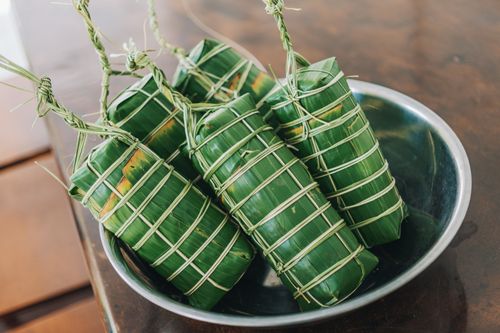 Free Close-up of Asian food wrapped in green leaves, presented in a steel bowl. Perfect for culinary themes. Stock Photo