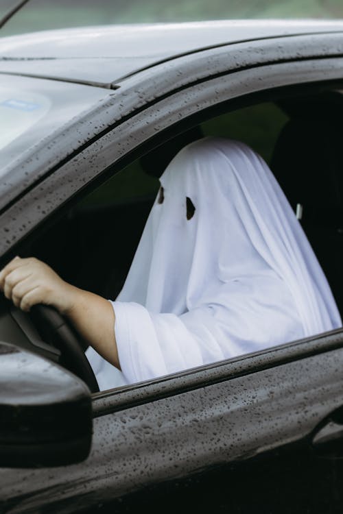 Free Man Wearing Ghost Costume Driving a Car  Stock Photo