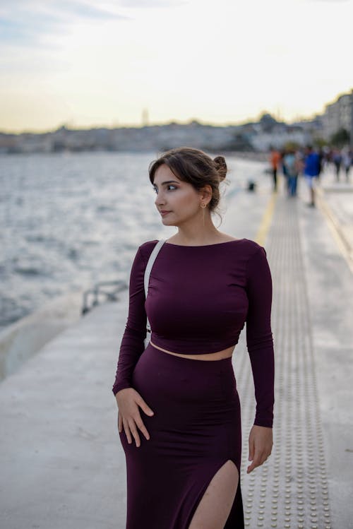 Young Woman Standing on the Sidewalk by the Sea 