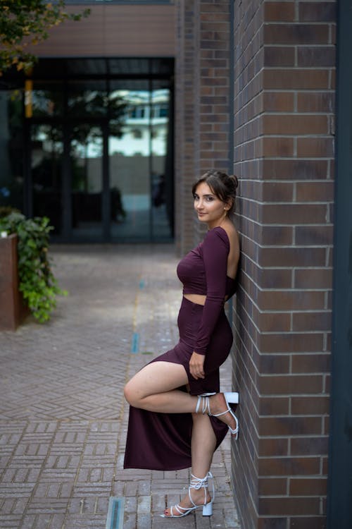 Young Elegant Woman Standing with Her Back against the Wall 