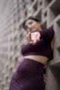 Woman Standing by the Wall with Her Arm Reached Toward the Camera