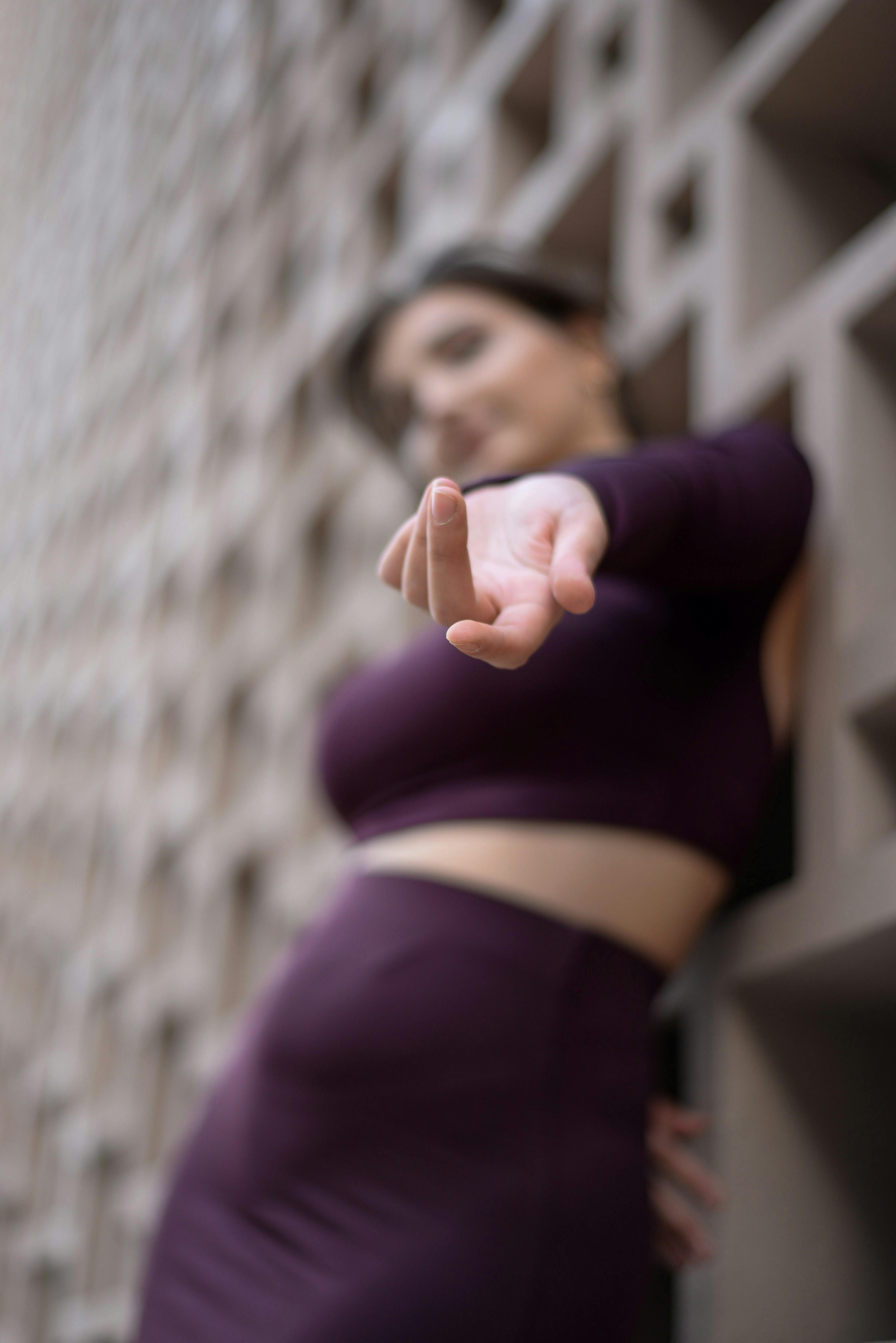 Free Artistic photo of a woman reaching out in a modern urban setting, with a focus on her hand. Stock Photo
