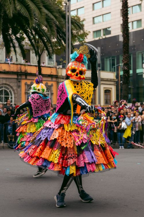 Free Colorful dancers celebrate Dia de Muertos in a lively street parade in Mexico. Stock Photo