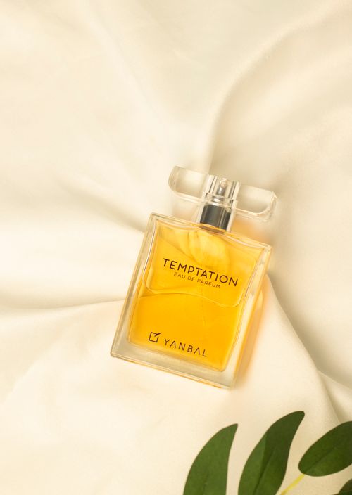 Free Luxurious perfume bottle on silky satin with a hint of nature. Stock Photo