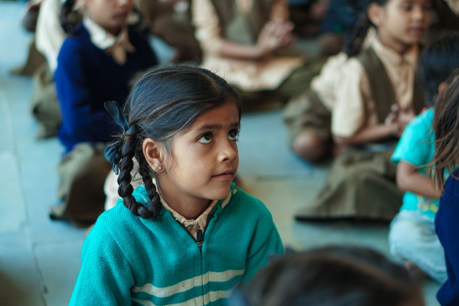 A young Indian student writing in a notebook