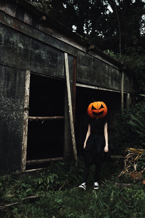 Woman Wearing a Carved Pumpkin on Her Head