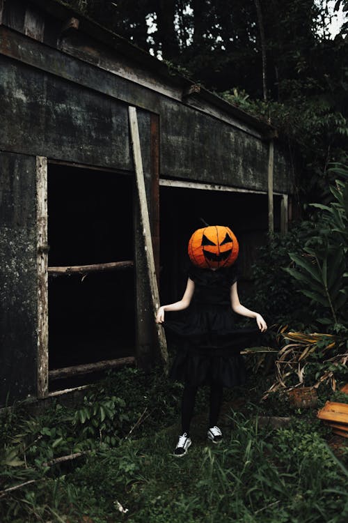 Woman Wearing a Carved Pumpkin on Her Head