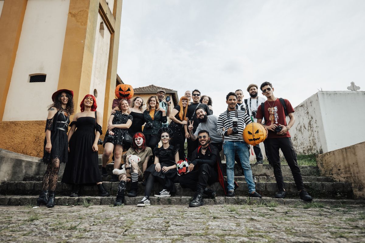 Group of friends wearing Halloween costumes and posing with pumpkins