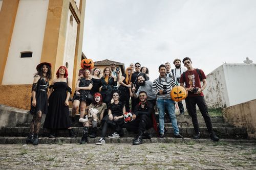 Free A cheerful group in Halloween costumes with pumpkins on outdoor stone steps. Stock Photo