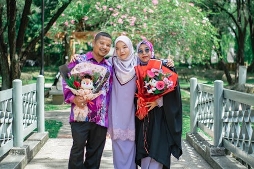 Mother and Father with Graduate Daughter in Park