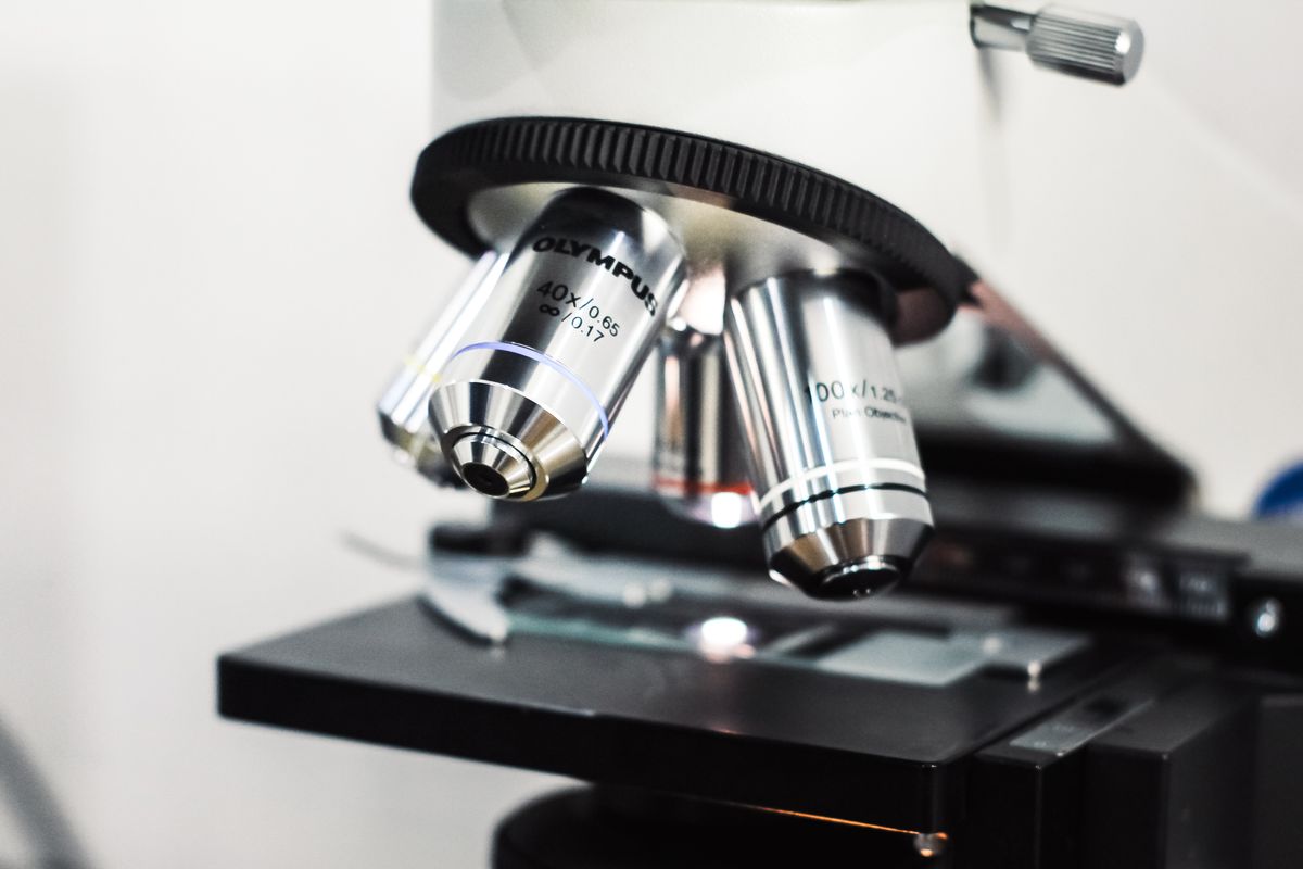 Detailed view of an Olympus microscope used for scientific research in a laboratory setting. Illustrative editorial photograph.