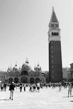 Black and white photo of San Marco Piazza, capturing St. Mark's Basilica and Bell Tower in Venice, Italy.
