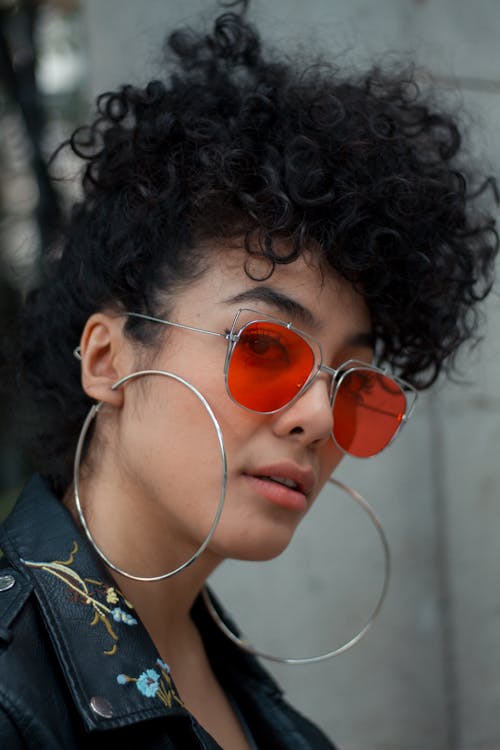 Portrait of Woman Wearing Red Sunglasses and Hoop Earrings