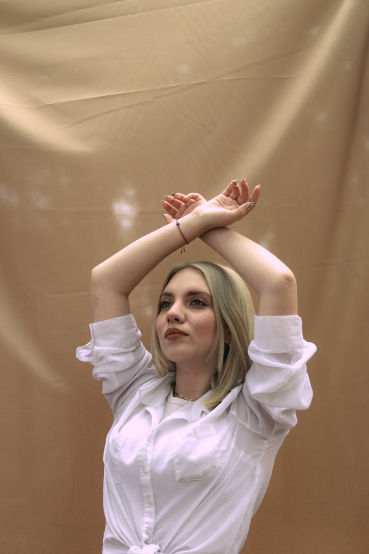 Woman In White Blouse Posing With Hands Crossed Above Head