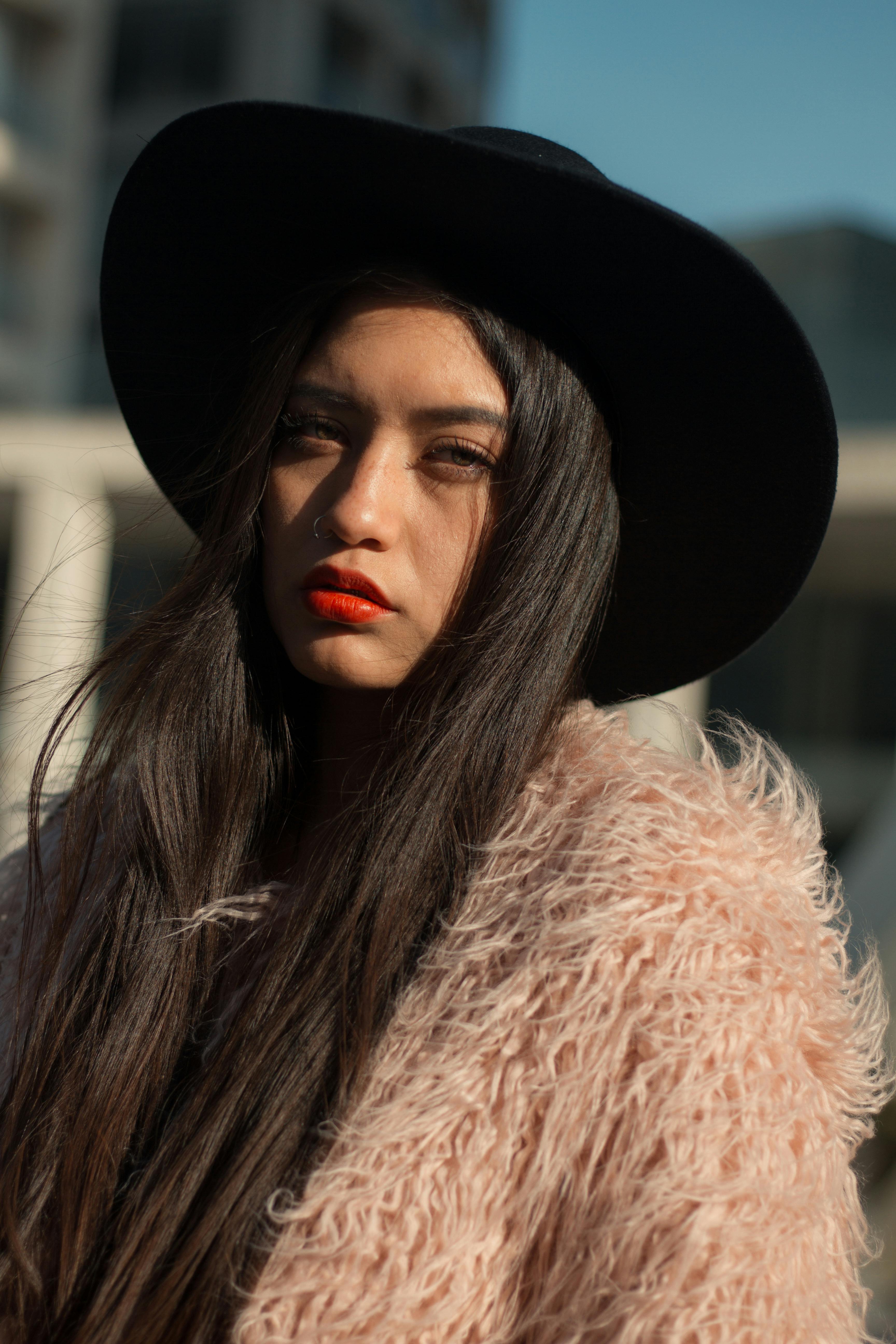 Young Woman in a Black Coat Standing against a Wall with Peeling