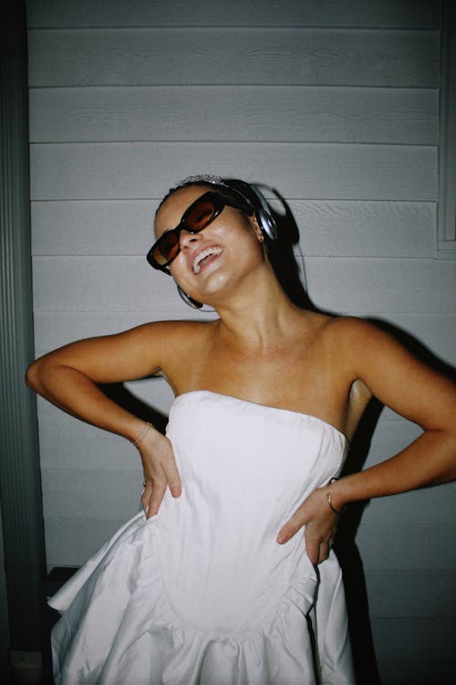 Smiling Woman in White Dress, Headphones and Sunglasses