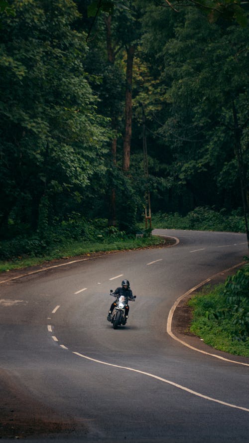 Person Riding a Motorcycle on a Winding Road 