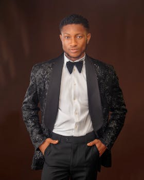 Elegant portrait of a young man in a black tuxedo with a bow tie, exuding sophistication.