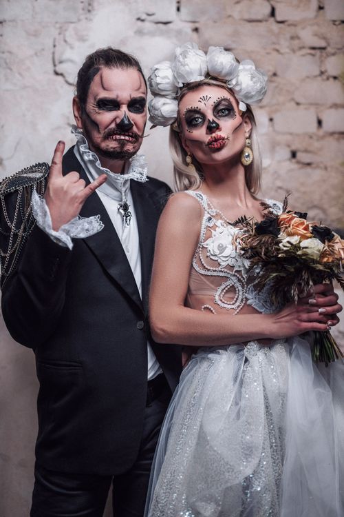 Free A couple celebrates Halloween with Dia de los Muertos inspired wedding attire and makeup. Stock Photo