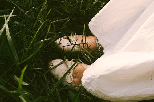 Close up of Woman Shoes and White Dress on Grass