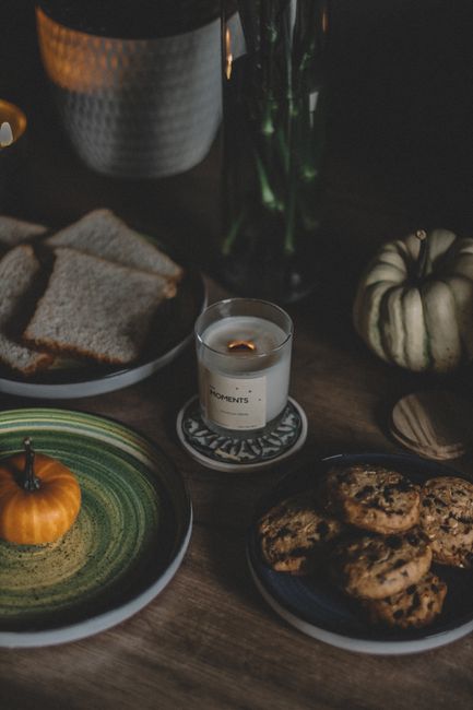 A warm, inviting scene of bread, cookies, and a pumpkin candle, perfect for fall gatherings.