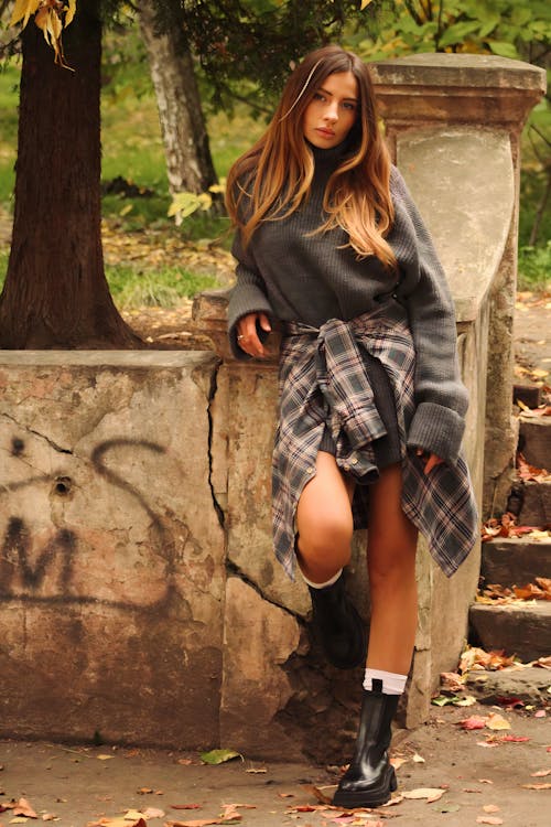 Model in a Gray Sweater and Boots Posing in a Park