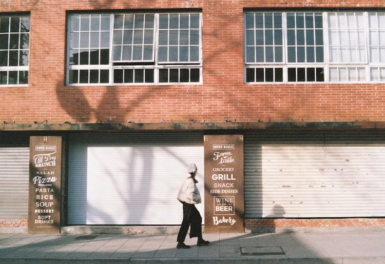 Person Walking In Front Of A Closed Restaurant