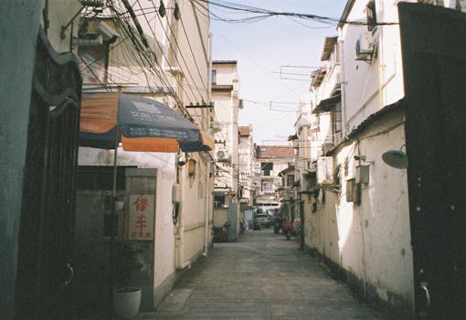 Narrow urban alley with overhead cables and buildings reflecting a classic cityscape.