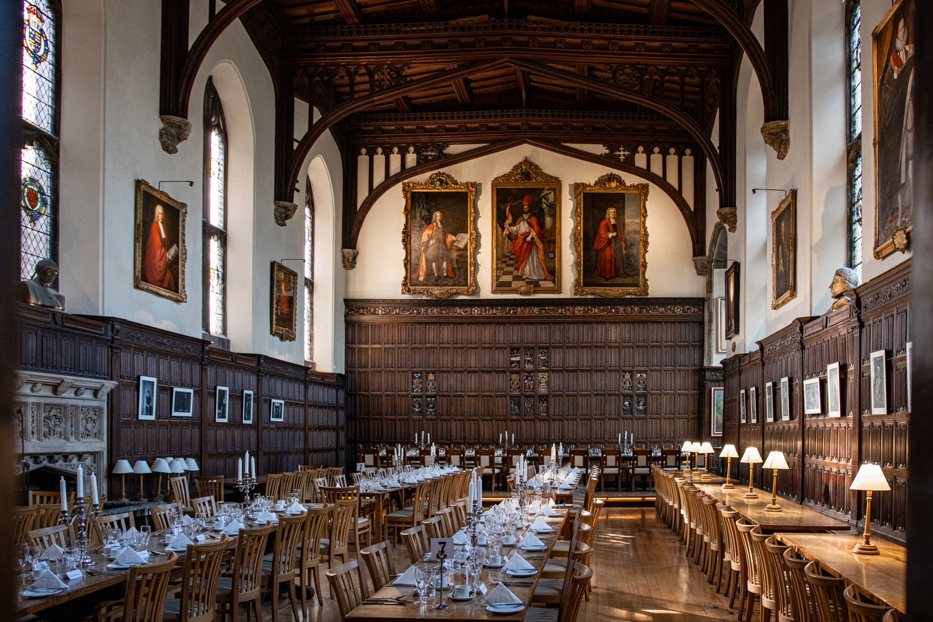 Historic dining hall with elaborately set tables in Magdalen College, Oxford.