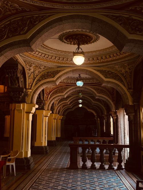 Free Intricate vintage corridor with detailed archways and warm lighting. Stock Photo