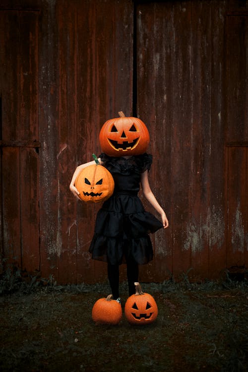 Woman Wearing a Carved Pumpkin on Her Head 