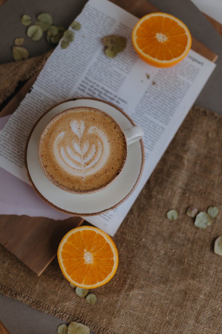 Coffee Cup On Plate And Orange Halves Around