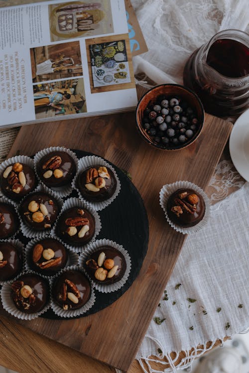 Tray of Chocolate Nut Cupcakes an a Bowl of Blueberries on Cutting Board