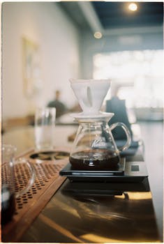 Stylish coffee brewing with a Kalita dripper in a cozy café setting.