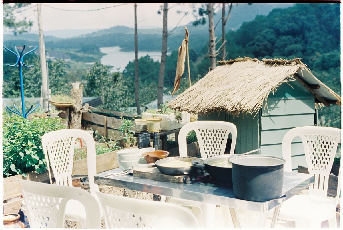 Outdoor tables overlooking a lake and wooded hills in Da Lat